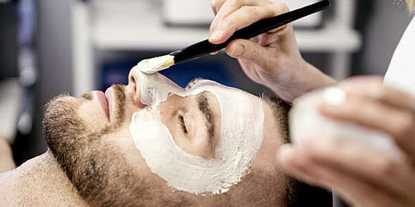 Young man receiving a facial treatment in a health beauty spa.