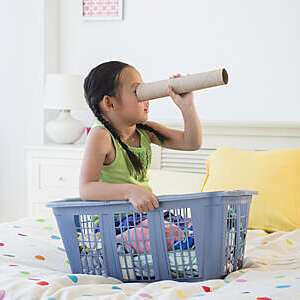 Korean girl looking through cardboard tube
