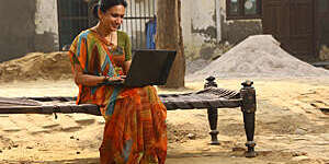 Indian Happy rural women working on laptop in village. 